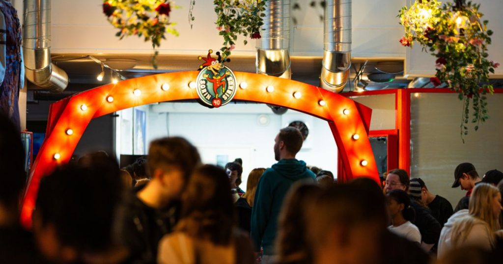 Sorin Sirkuksen aula: kuvan keskellä oranssein valoin koristeltu portti ja ihmisjoukko.